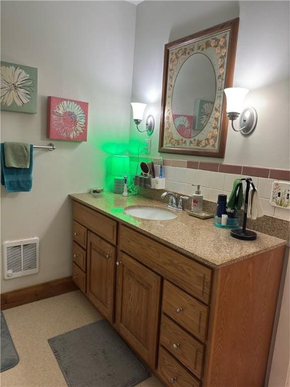 bathroom with visible vents, baseboards, decorative backsplash, and vanity