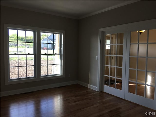 spare room featuring baseboards, dark wood-style flooring, french doors, and ornamental molding