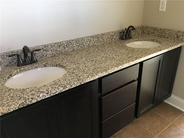 bathroom featuring double vanity, tile patterned flooring, and a sink