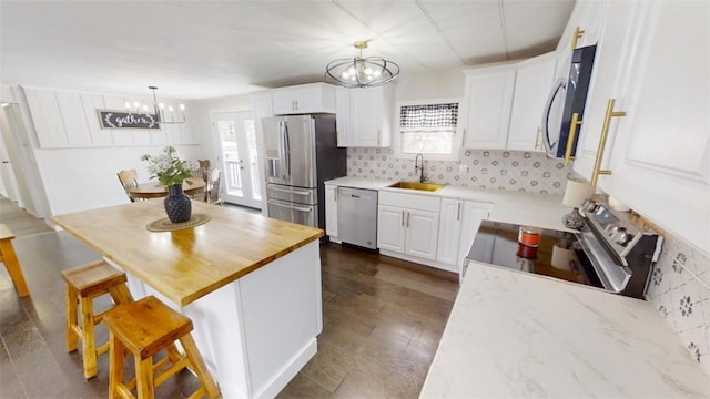 6339 County Road 32, North Norwich, NY 13815 - kitchen featuring an inviting chandelier, a sink, white cabinets, and stainless steel appliances