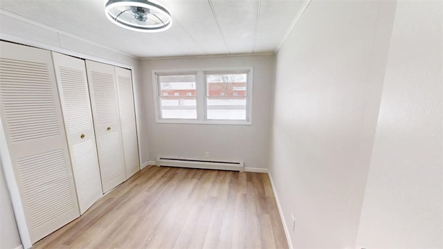 6339 County Road 32, North Norwich, NY 13815 - unfurnished bedroom with a closet, light wood-type flooring, baseboards, ornamental molding, and a baseboard radiator