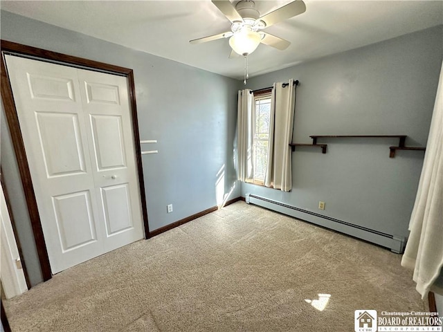 unfurnished bedroom with baseboards, ceiling fan, baseboard heating, carpet flooring, and a closet