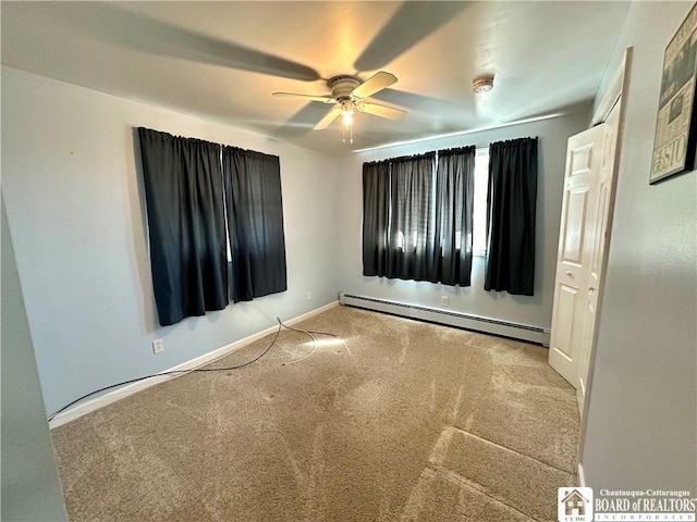 spare room with a baseboard heating unit, baseboards, a ceiling fan, and carpet flooring