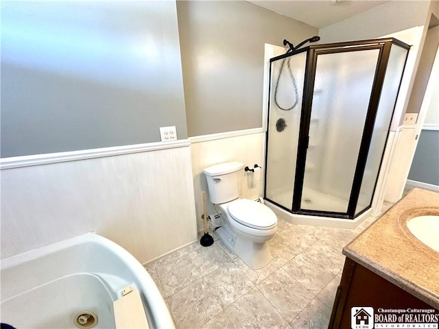 bathroom featuring a wainscoted wall, a washtub, toilet, a stall shower, and vanity