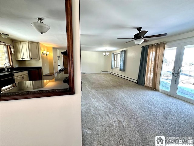 kitchen featuring dark countertops, baseboard heating, carpet flooring, dishwashing machine, and a sink