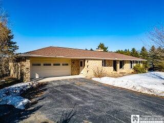 single story home featuring a garage and driveway