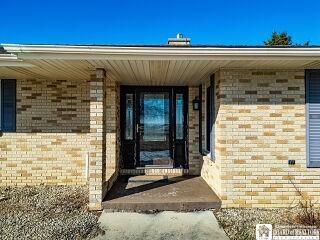 entrance to property featuring brick siding and a porch