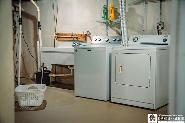 clothes washing area with a sink, washing machine and dryer, and laundry area