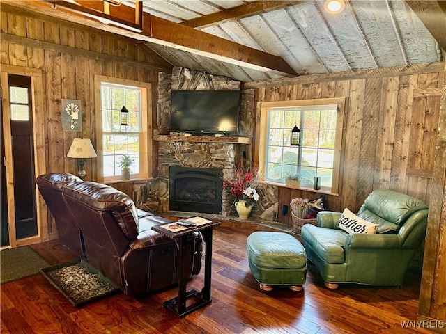 living room featuring hardwood / wood-style flooring, vaulted ceiling with beams, a fireplace, and plenty of natural light