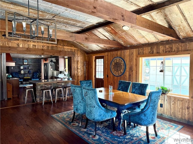 dining space with lofted ceiling with beams, wood-type flooring, and wood walls