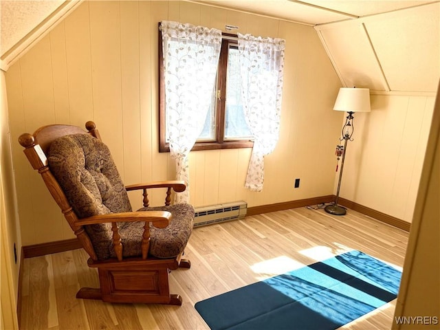 sitting room with vaulted ceiling, wood finished floors, baseboards, and a baseboard radiator