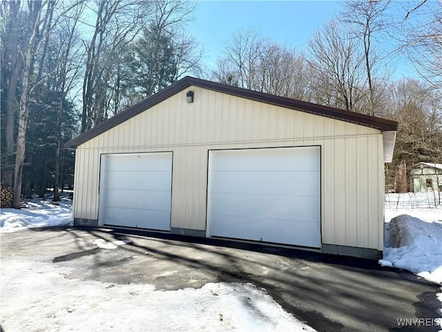 snow covered garage featuring a detached garage