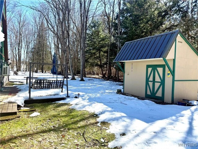 yard layered in snow with a shed and an outdoor structure