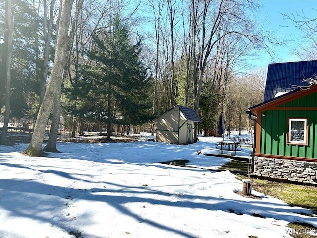 yard layered in snow with an outbuilding and a storage unit