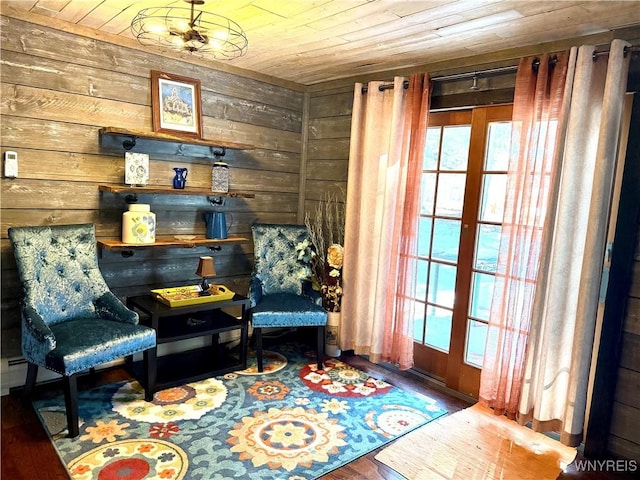 sitting room with wooden walls, wooden ceiling, and wood finished floors