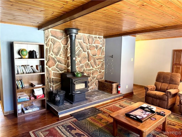 living room with wood ceiling, beam ceiling, a wood stove, and wood finished floors