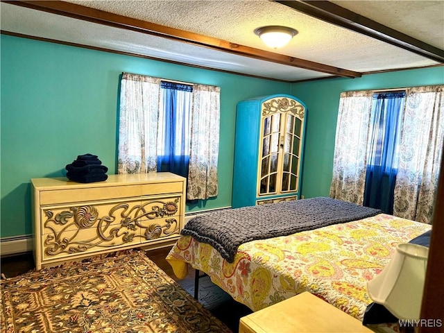 bedroom featuring beam ceiling, baseboard heating, and a textured ceiling