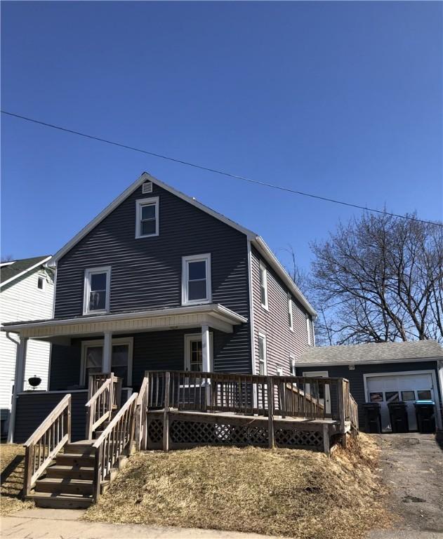 american foursquare style home with a garage, covered porch, and driveway