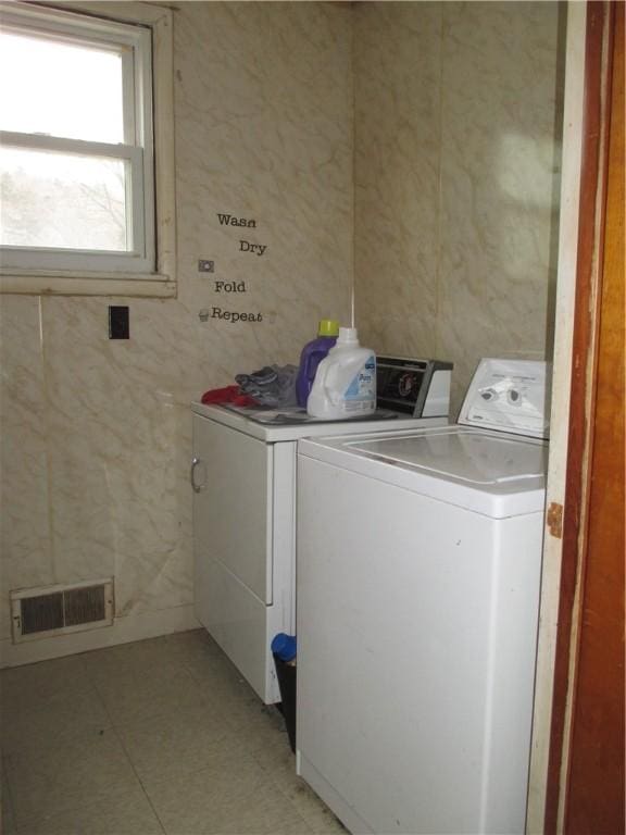 laundry room with laundry area, washing machine and dryer, and visible vents