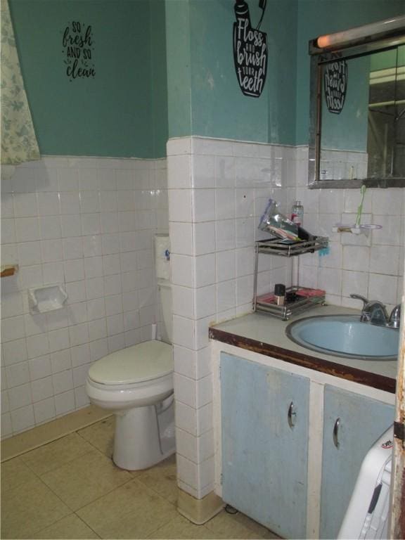 bathroom with tile patterned floors, toilet, vanity, and tile walls