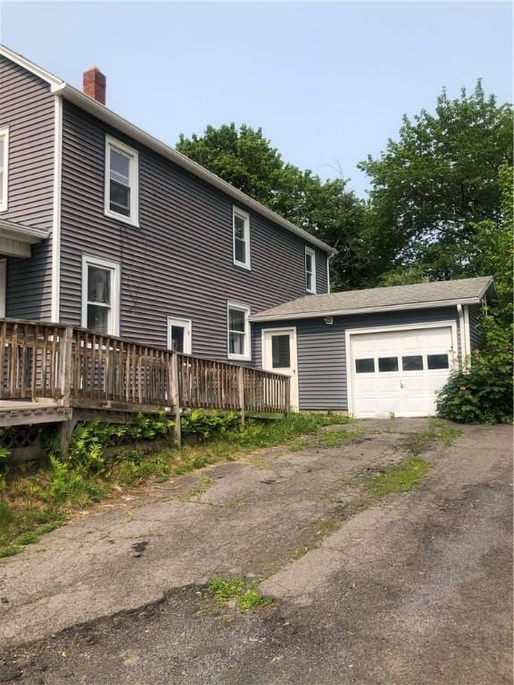 15 8th St, Oneonta-City, NY 13820 - view of home's exterior featuring a chimney, a wooden deck, asphalt driveway, and an attached garage