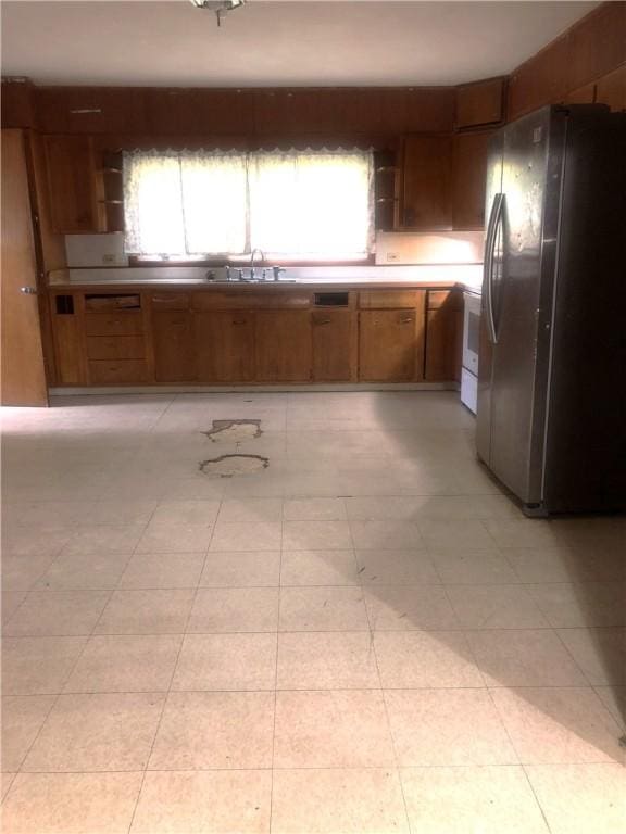 15 8th St, Oneonta-City, NY 13820 - kitchen featuring freestanding refrigerator, brown cabinetry, and a sink