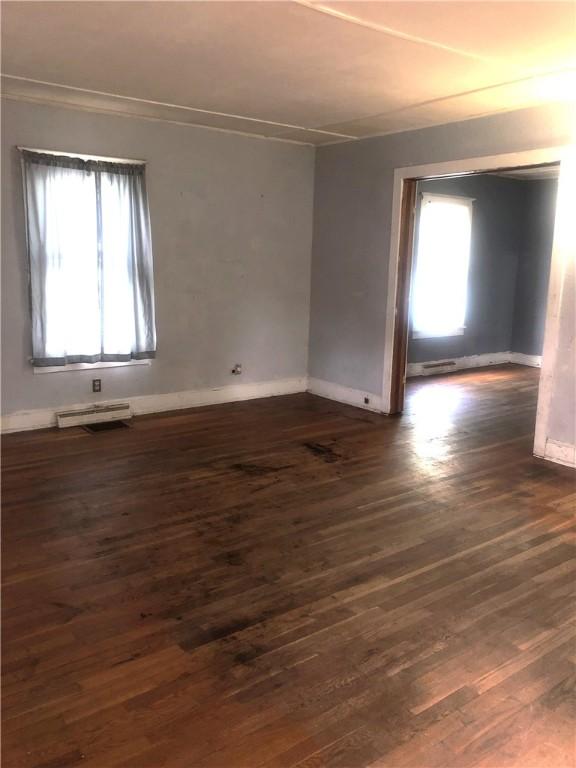 15 8th St, Oneonta-City, NY 13820 - empty room featuring dark wood-style floors, plenty of natural light, baseboards, and crown molding