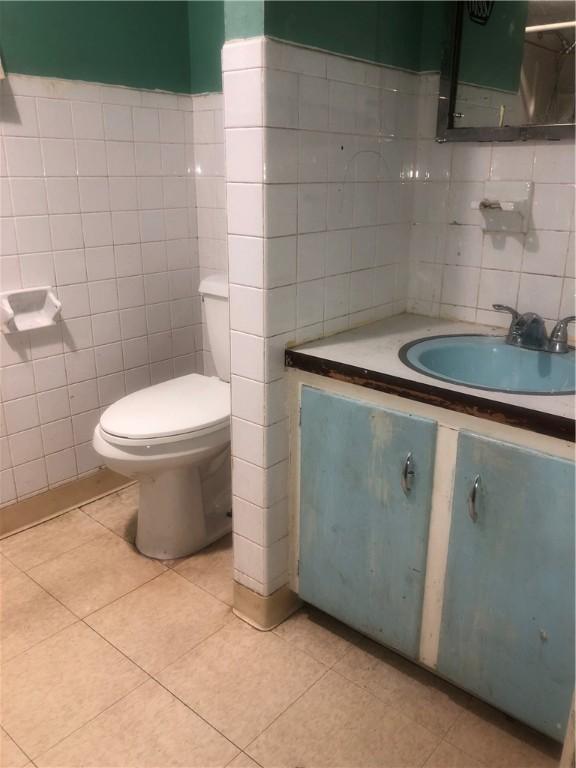 15 8th St, Oneonta-City, NY 13820 - bathroom with tile walls, toilet, vanity, and tile patterned flooring