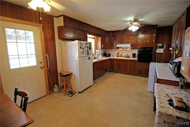 kitchen featuring a ceiling fan, freestanding refrigerator, oven, light countertops, and under cabinet range hood