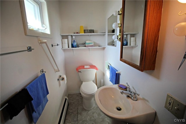 bathroom with a baseboard heating unit, toilet, and a sink