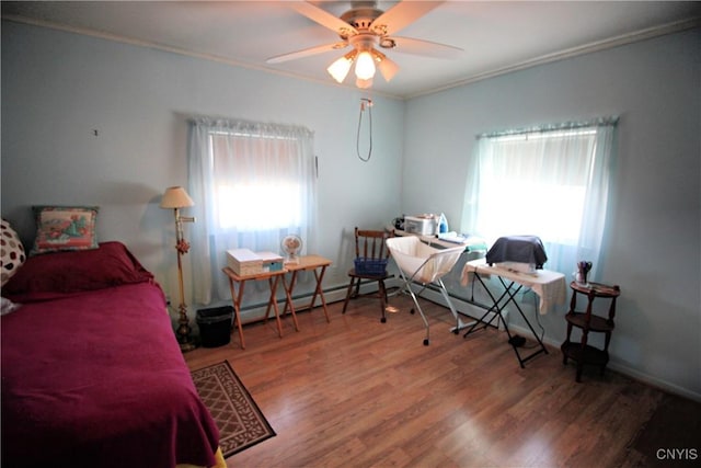 bedroom featuring ceiling fan, multiple windows, wood finished floors, and ornamental molding