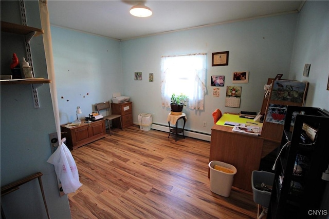 home office with light wood-type flooring, a baseboard heating unit, and ornamental molding