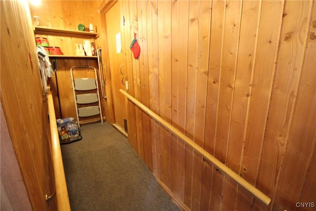 hall with wood walls and carpet floors