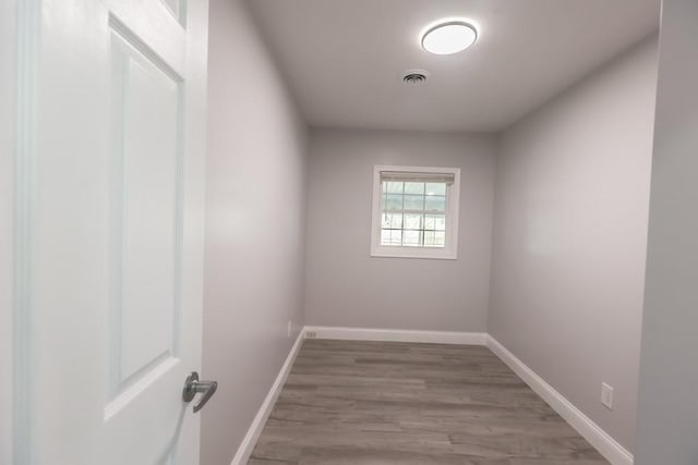 empty room featuring visible vents, baseboards, and wood finished floors