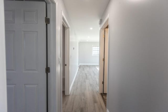 hall with recessed lighting, light wood-style floors, and baseboards