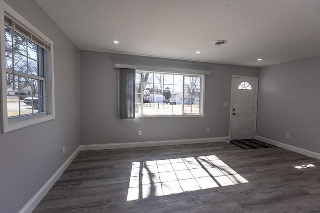 entrance foyer featuring a wealth of natural light, visible vents, baseboards, and wood finished floors