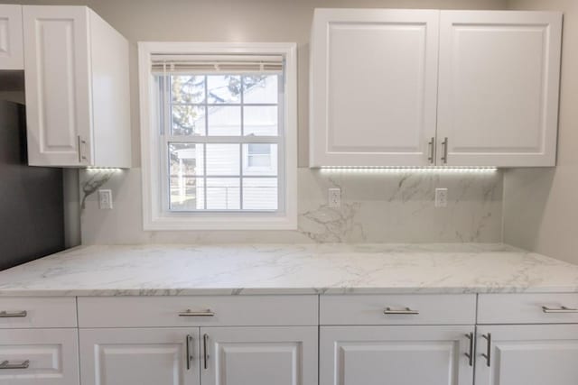 kitchen with light stone counters and white cabinetry