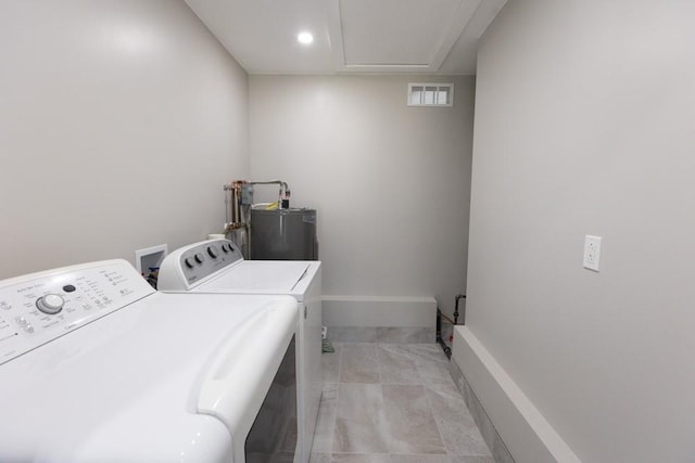 laundry area featuring visible vents, washer and clothes dryer, water heater, baseboards, and laundry area