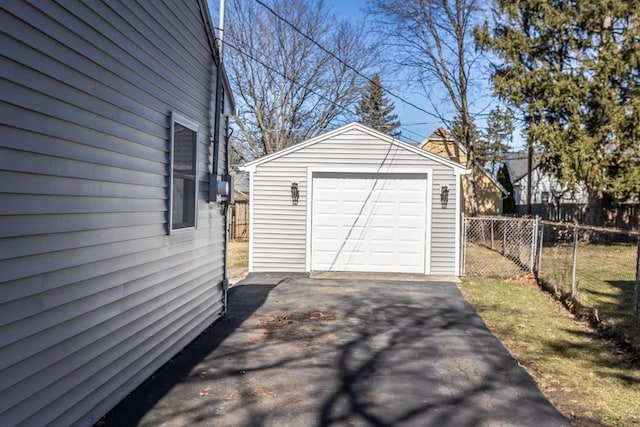 detached garage with aphalt driveway and fence