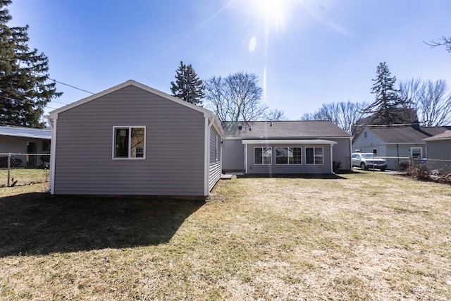 back of house featuring a yard and fence