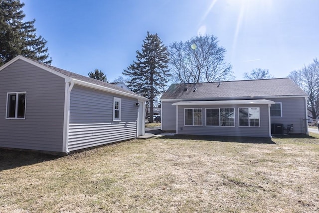 back of property featuring cooling unit and a lawn