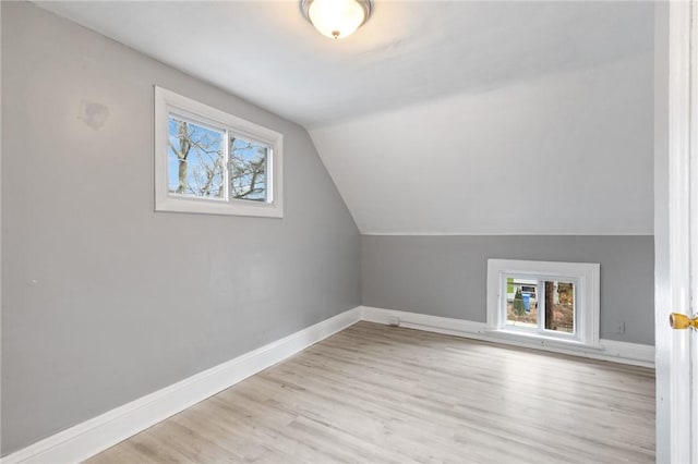 bonus room featuring vaulted ceiling, plenty of natural light, wood finished floors, and baseboards