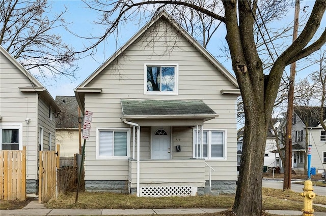 bungalow-style house with fence and a shingled roof