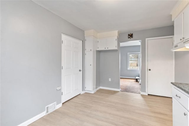 kitchen featuring baseboards, visible vents, white cabinetry, and light wood-style floors