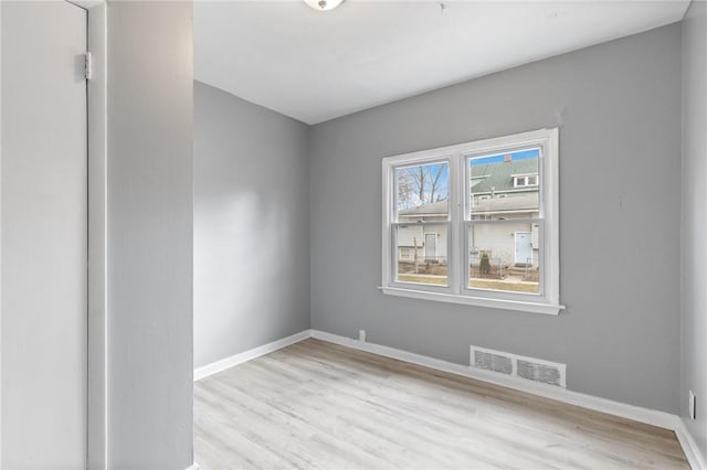 empty room with visible vents, baseboards, and wood finished floors