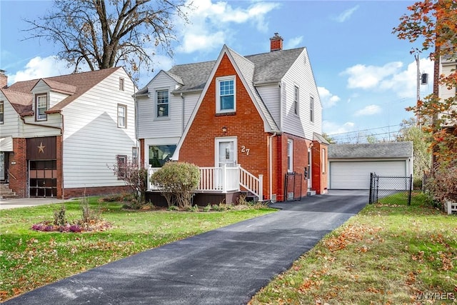 view of front of house featuring a front lawn, an outdoor structure, a garage, brick siding, and a chimney