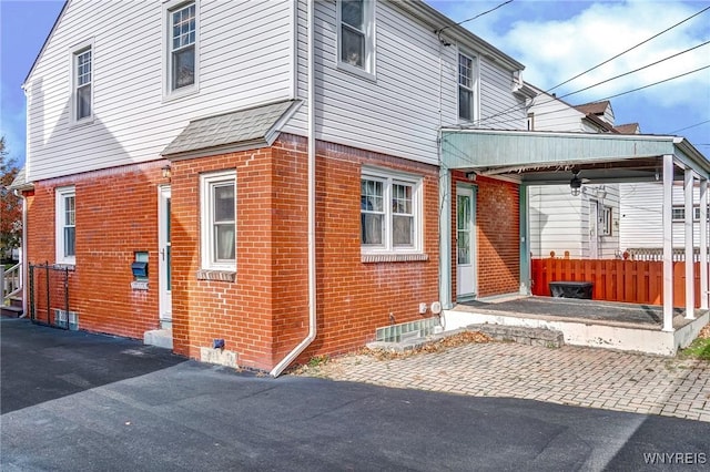 exterior space featuring brick siding and fence