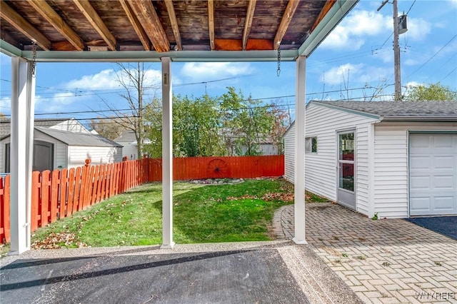 view of yard featuring a patio area, an outbuilding, and fence