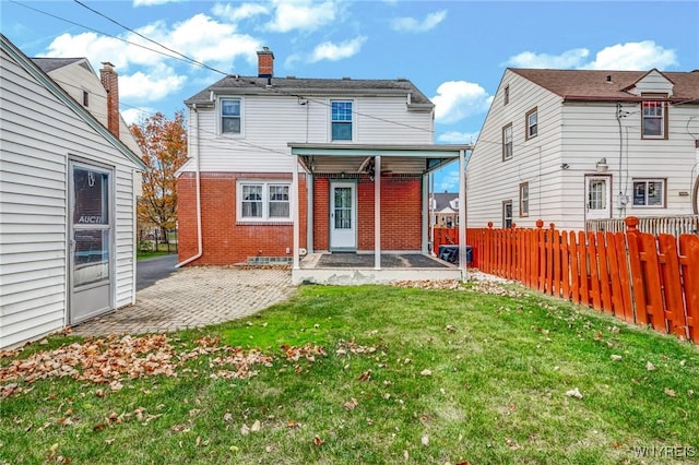 back of property featuring a yard, brick siding, a patio, and fence