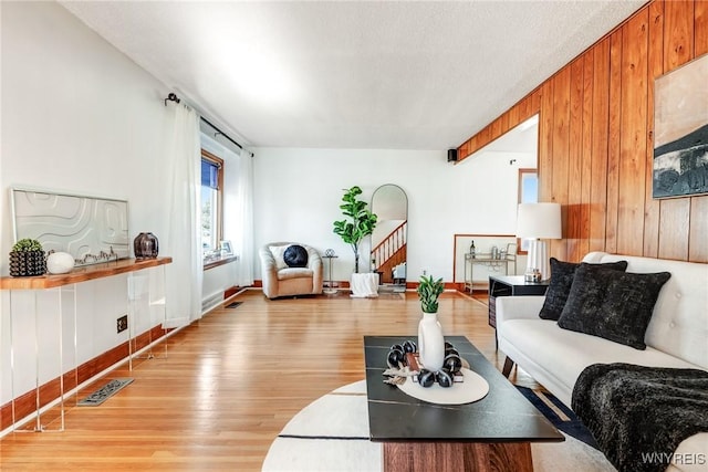 living room with visible vents, wood finished floors, and stairs